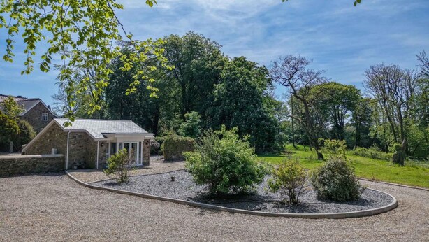 A stone building with a gravel driveway and a circular garden area. - The Pig Sty - 1 Bedroom Studio - Princes Gate (Narberth)