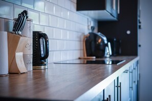 Een aanrecht met een koffiezetapparaat, een messenblok en een keukenpapierhouder.