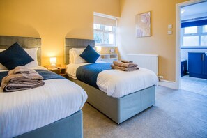 Ein Hotelzimmer mit zwei Betten, Blick nach außen und einem durchgegangenen Türsinn erreichbaren Badezimmer.
