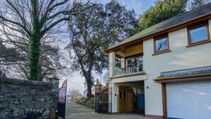 A two-story house with a garage, a stone wall, and a gate. - Marina House Annex - 1 Bedroom - Neyland (Milford Haven)