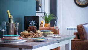 Comedor con una mesa dispuesta para dos, que presenta una variedad de platos y una botella de champán.