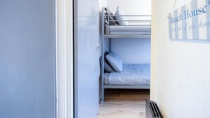 A bunk bed room with a sign reading "Beach House" and a reminder to take off shoes. - Swanbrook - 2 Bedroom Chalet- Freshwater East (Pembroke)