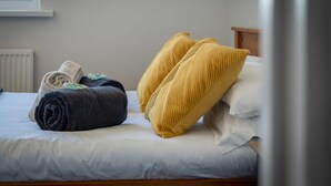 Un lit bien fait, avec des serviettes pliées et deux oreillers.