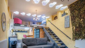 A cozy living room with a sofa, a coffee table, and a staircase. - Clouds - 1 Bedroom Holiday Home - Milford Haven (Milford Haven)