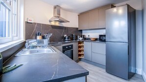 Una cocina moderna con una isla grande, electrodomésticos de acero inoxidable y vistas a la ciudad.