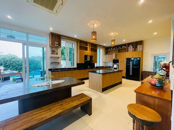Una cocina moderna con una isla central, muebles de madera y un ventanal con vistas al exterior.
