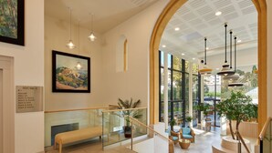 A spacious lobby with a high ceiling, large windows, and a staircase leading to upper floors. - Zenao Appart'hôtels Marseille Prado (Marseille)