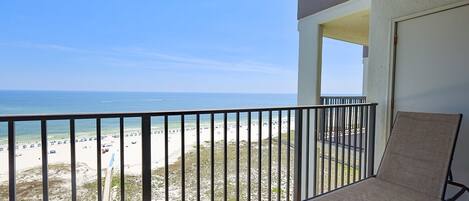 A balcony with a view of a beach and ocean.