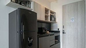 A modern kitchen with a black refrigerator, wooden cabinets, and a microwave. - w Scenic 3BR w Ocean View Near C Amurallada (Cartagena)
