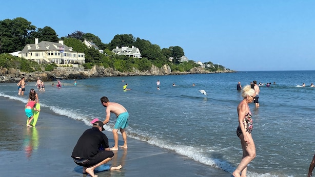 A beach with people engaging in various activities, a clear sky, and houses in the background. - Bright 3BR House • New patio, Fire Pit, Outdoor Shower, EV Charger • Beach 4min (York)