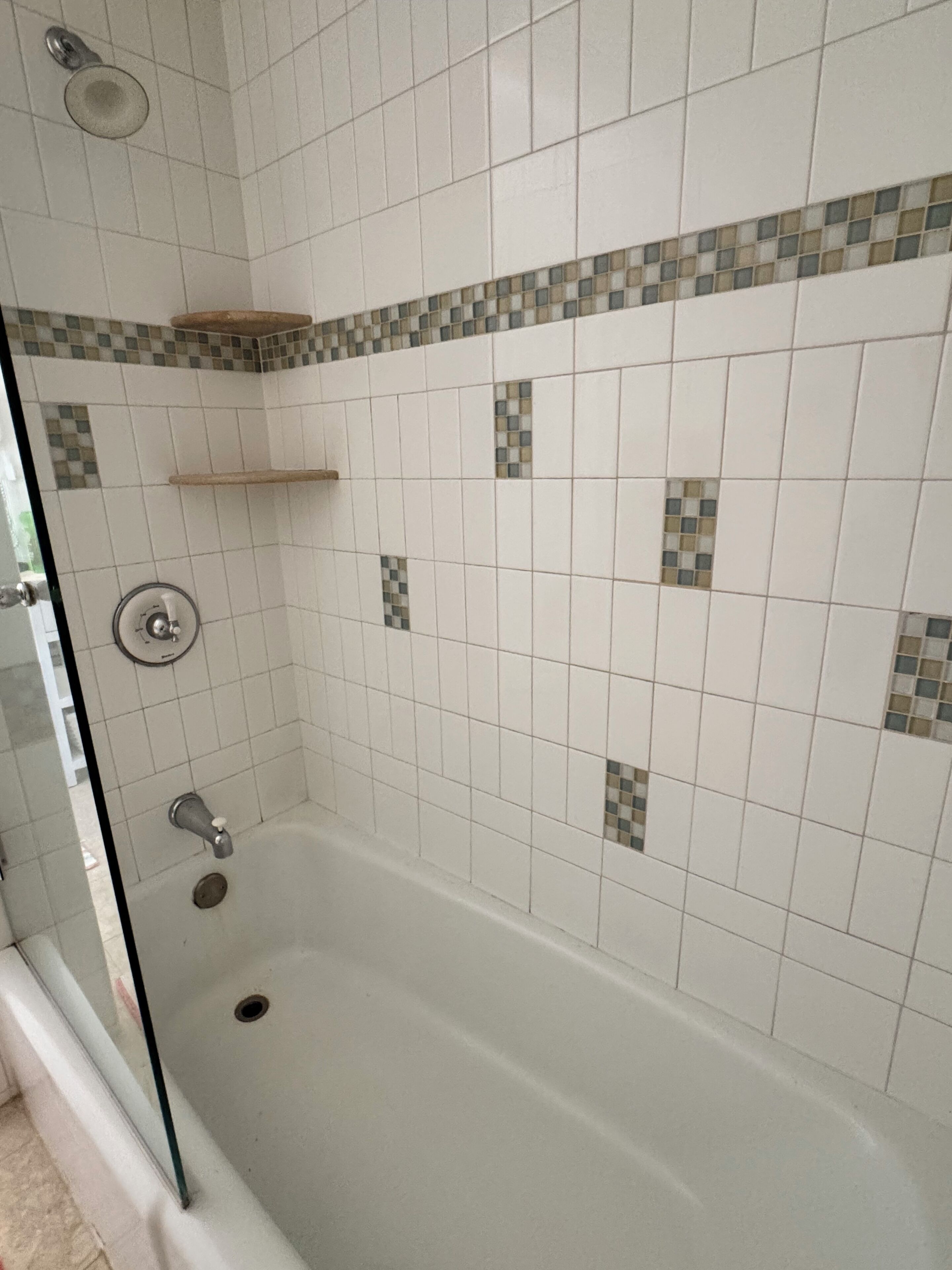 A bathroom with a bathtub, a shower, and a glass door.