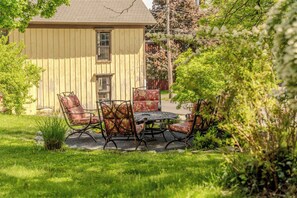 Une maison dotée d’un patio comprenant une table et quatre chaises.