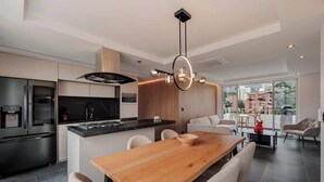 A modern kitchen with a wooden dining table, built-in appliances, and a pendant light. - lEPl Modern Apt, AC, Nice View, Balcony, Provenza (Medellín)