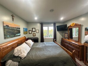 A bedroom with a bed, a wooden dresser, a television, and framed certificates on the wall. - Stunning 1BR Bird Island Overlook near Klondike Trail in Elliston (Elliston)