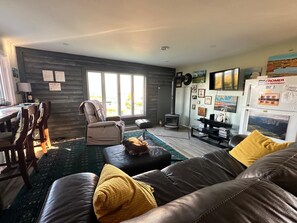 A cozy living room with a leather sofa, a chair, a small table, and a fireplace. - Stunning 1BR Bird Island Overlook near Klondike Trail in Elliston (Elliston)