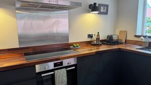 A modern kitchen with stainless steel appliances, a wooden countertop, and a window with a view. - Peaceful Hastings old town hideaway (Hastings)