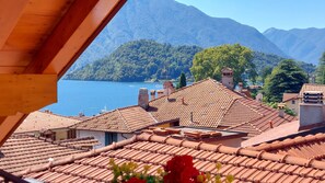 A coastal village with terracotta-tiled roofs, a lake, and mountains in the background. - Cosy retreat, historical village on Lake Como, close to lake/services with views (Azzano)