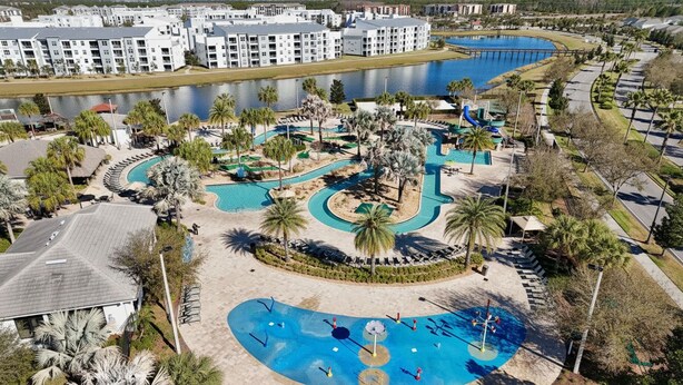 Ein Resort mit mehreren Swimmingpools, Palmen und einem großen Gebäudekomplex im Hintergrund.