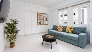 A modern living room with a sofa, a coffee table, and a potted plant.