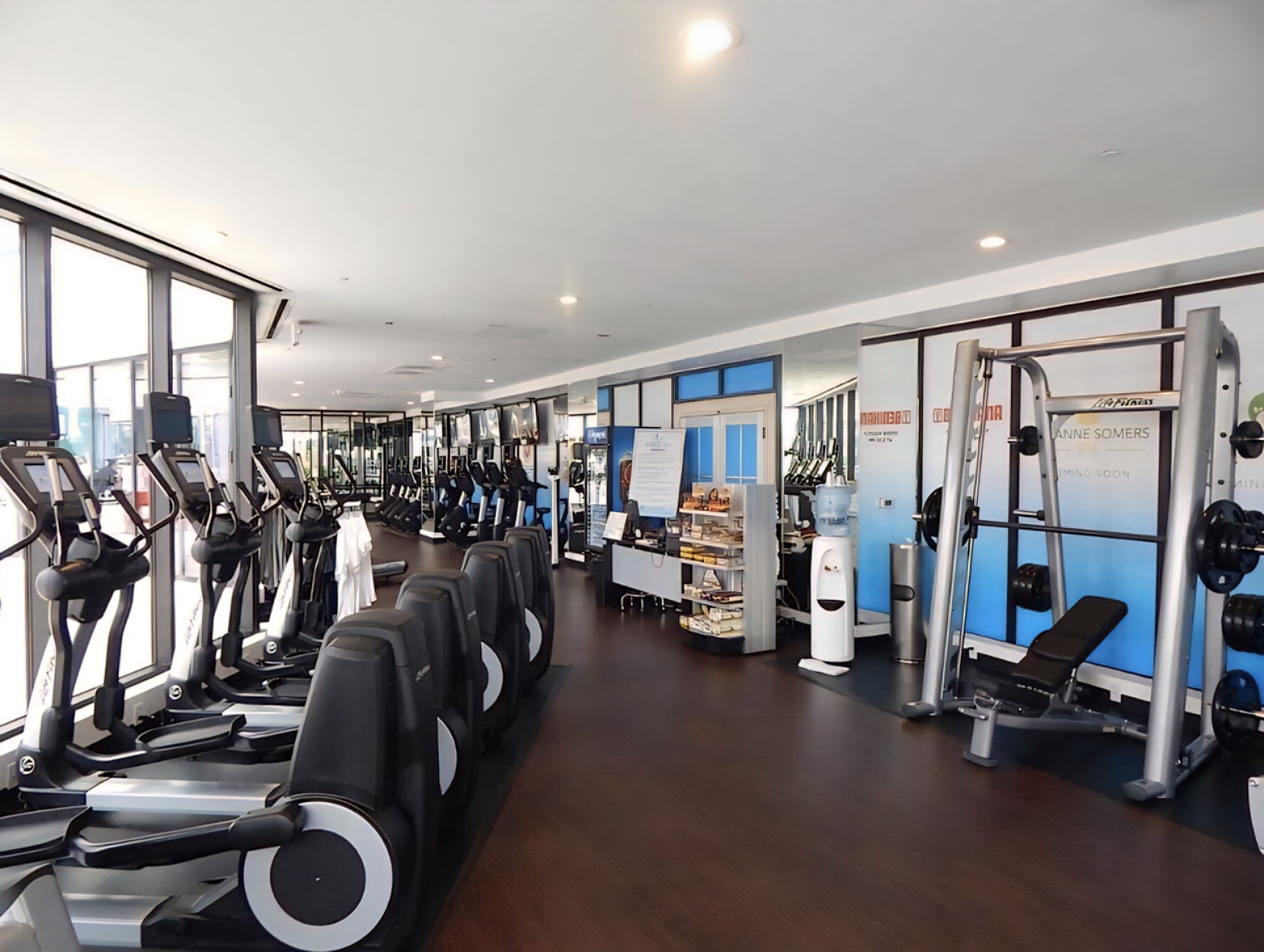 A gym with treadmills, weight machines, and a water dispenser.