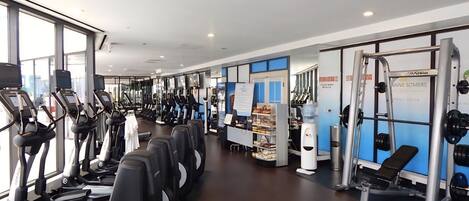 A gym with treadmills, weight machines, and a water dispenser.