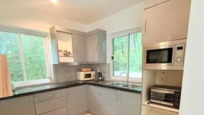 A modern kitchen with grey cabinets, a microwave, a toaster, and a sink. - Private Pool Villa • 4BR •Fast Wifi • Koh Chang (Tambon Ko Chang)