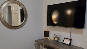A room with a desk, chair, TV, and a round mirror on the wall. - Private room in a Beautiful house Centrally Located  (Denton)