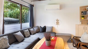 Una sala de estar moderna con un sofá gris, una mesa de centro de madera y una estantería.