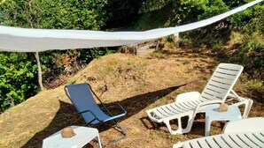 A set of outdoor lounge chairs on a grassy slope with a white canopy overhead. - Apartment 'Altrove' with Mountain View, Private Garden and Wi-Fi (Ne)