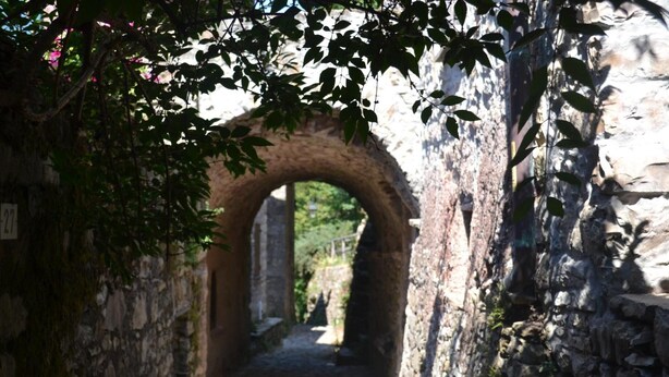 An arched stone passageway with a narrow path, surrounded by stone walls and foliage. - Apartment 'Altrove' with Mountain View, Private Garden and Wi-Fi (Ne)