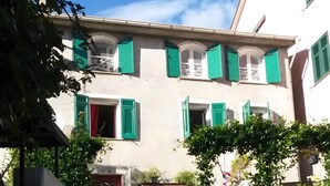 A building with multiple windows, a stone staircase, and a stone wall. - Apartment 'Altrove' with Mountain View, Private Garden and Wi-Fi (Ne)