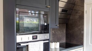 A modern kitchen with a built-in microwave, oven, and stainless steel appliances. - Pleasant Studio in St Albans (St Albans)