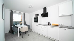 A modern kitchen with white cabinets, a built-in oven, and a stainless steel sink. - Favorite Stays - Düsseldorf (Düsseldorf)