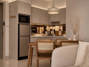 A modern kitchen with a built-in microwave, double oven, and a dining area with wooden chairs and a table.