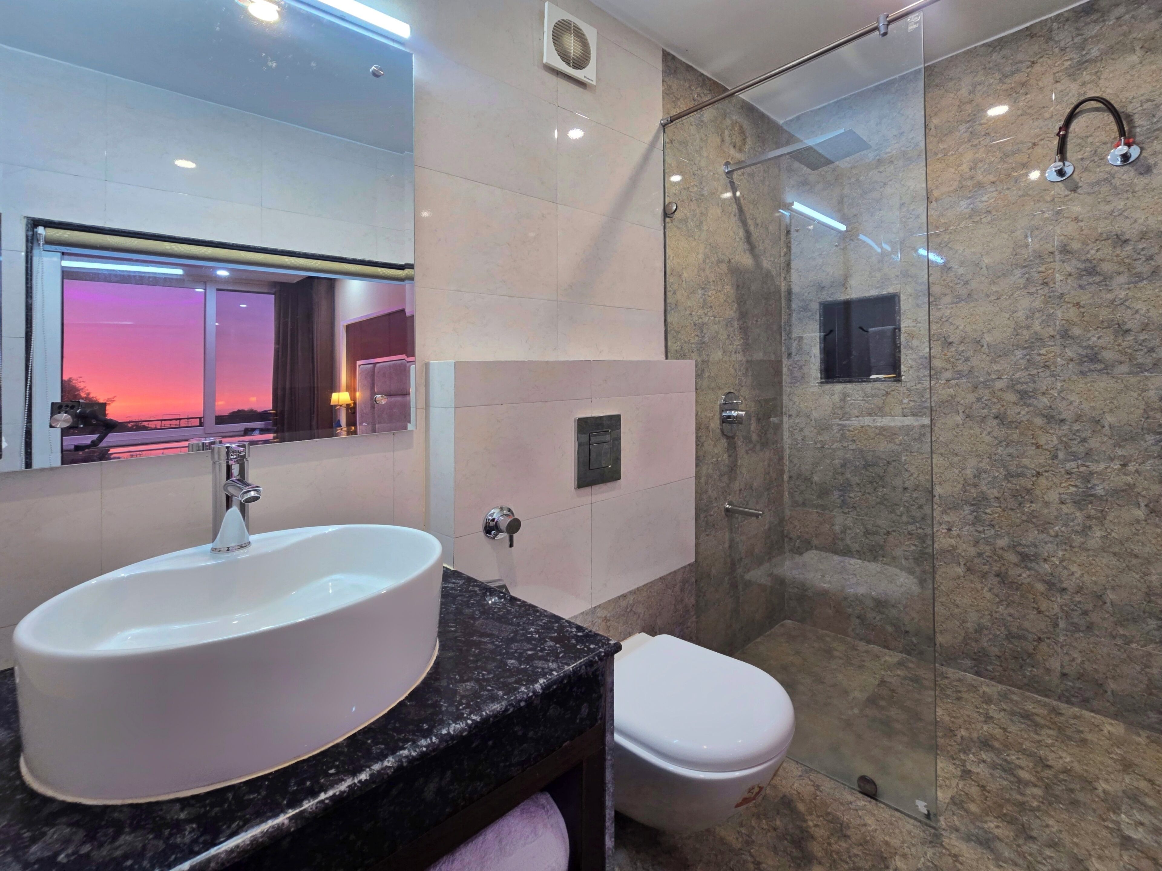 Ein modernes Badezimmer mit einem großen, weißen Waschbecken, einer Toilette und einer Duschkabine.