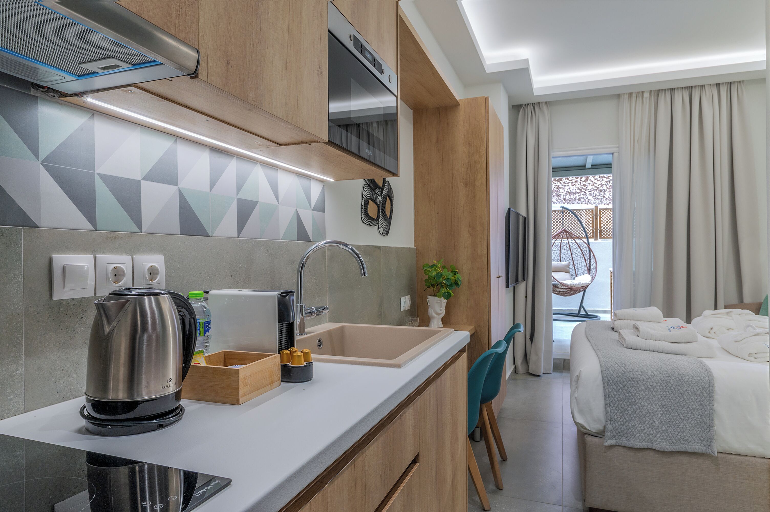 A modern kitchen with a kettle, toaster, and sink.