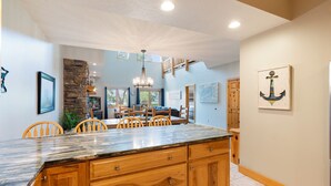 A spacious kitchen with a large island, wooden cabinets, and a stone accent wall.