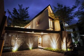 Una casa moderna con techo plano, entrada cubierta y acceso mediante portón.