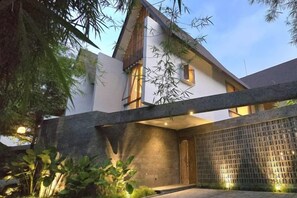 Une maison moderne avec une façade en pierre, un garage et une entrée bien éclairée.