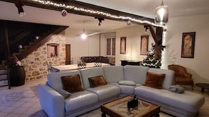 A living room with a light blue sofa, a wooden coffee table, and a staircase leading to a dining area. - Large capacity gîte in champagne.pets welcome! (Corrobert)
