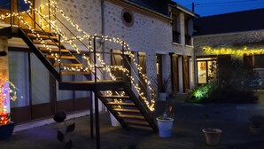 A staircase with string lights leading to a building entrance. - Large capacity gîte in champagne.pets welcome! (Corrobert)