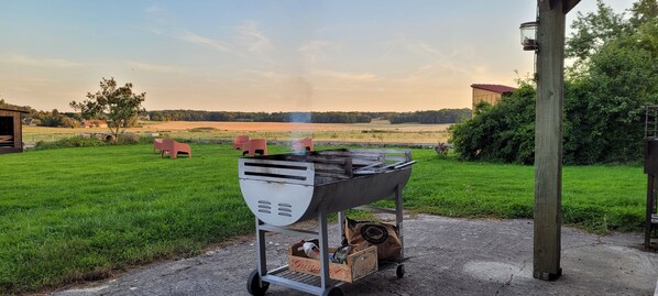 A barbecue grill with a cart, a wooden post, and a bag of charcoal. - Large capacity gîte in champagne.pets welcome! (Corrobert)