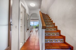 A staircase with patterned tiles and wooden steps leading to an upper floor.