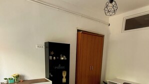 A bedroom with a bed, a dresser, a desk, a chair, and a wardrobe.