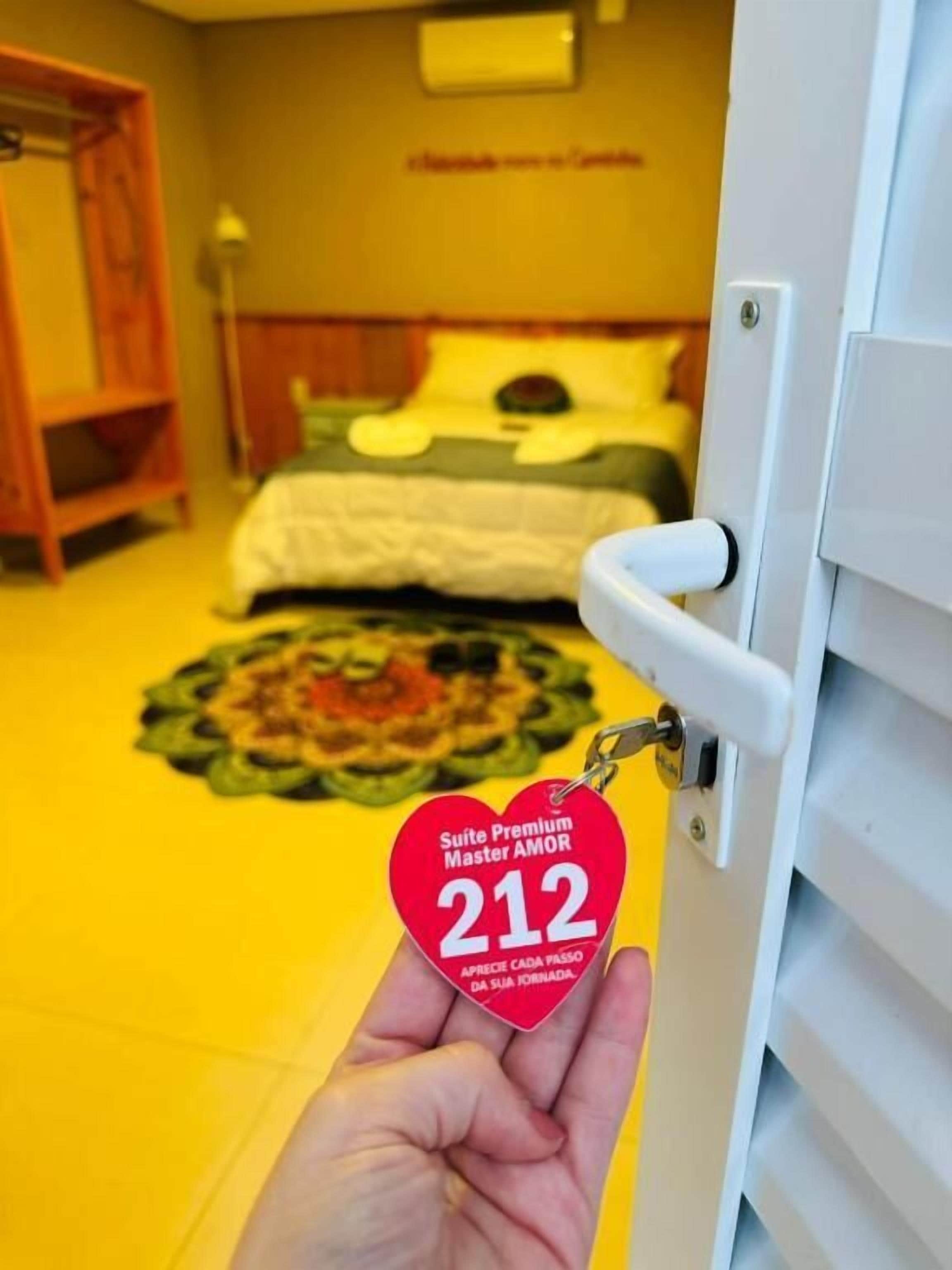 Una mano sosteniendo una tarjeta de acceso con un diseño en forma de corazón y el número 212.