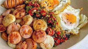 Een bord eten met worstjes, eieren en aardappelen.