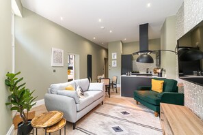 A modern living room with two sofas, a dining area, and a kitchen. - Chelmsford Loft 7 in Newcastle Upon Tyne (Newcastle-upon-Tyne)