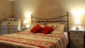 A bedroom with a bed, two bedside tables with lamps, a dresser, and a nightstand with a lamp. - A Stone's Throw from Aosta (Pollein)