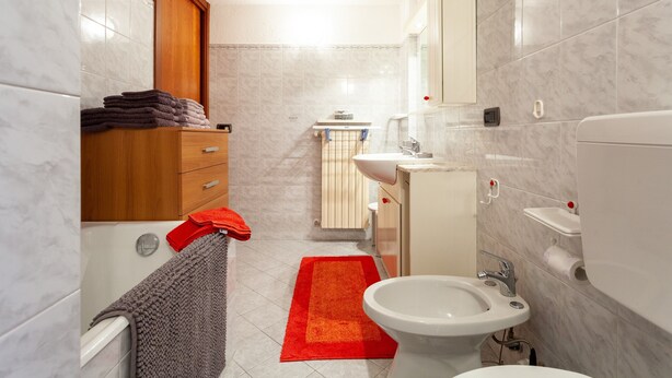 A bathroom with a bathtub, a sink, a toilet, and a bidet.