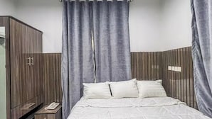 A bedroom with a bed, a wardrobe, and curtains. - Kpees Apartment (Abuja)